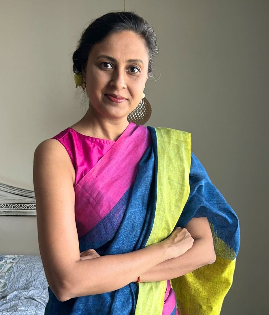 Woman wearing a colorful saree with a neutral background